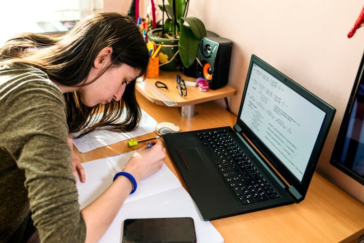 a student with hearing loss studies at her desk with a laptop